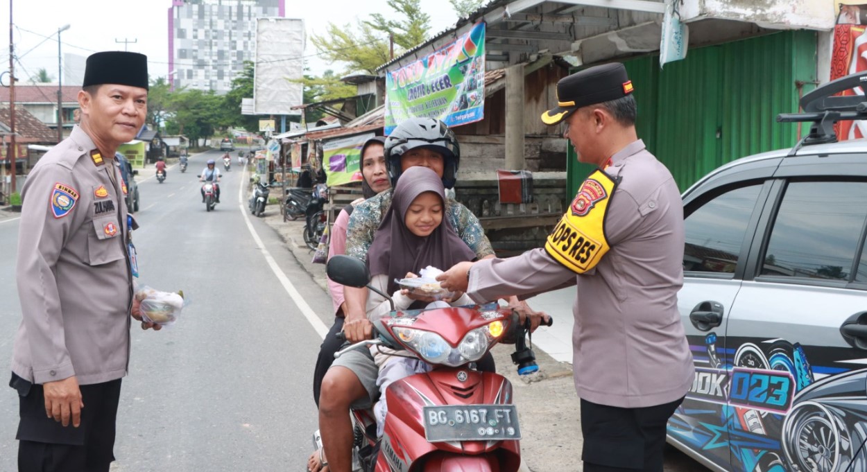 Wakapolres OKU, Kompol Yulfkri SH bagikan takjil kepada para pengendara yang melintas di Simpang 4 Ogan 2, Selasa, 4 Maret 2025.